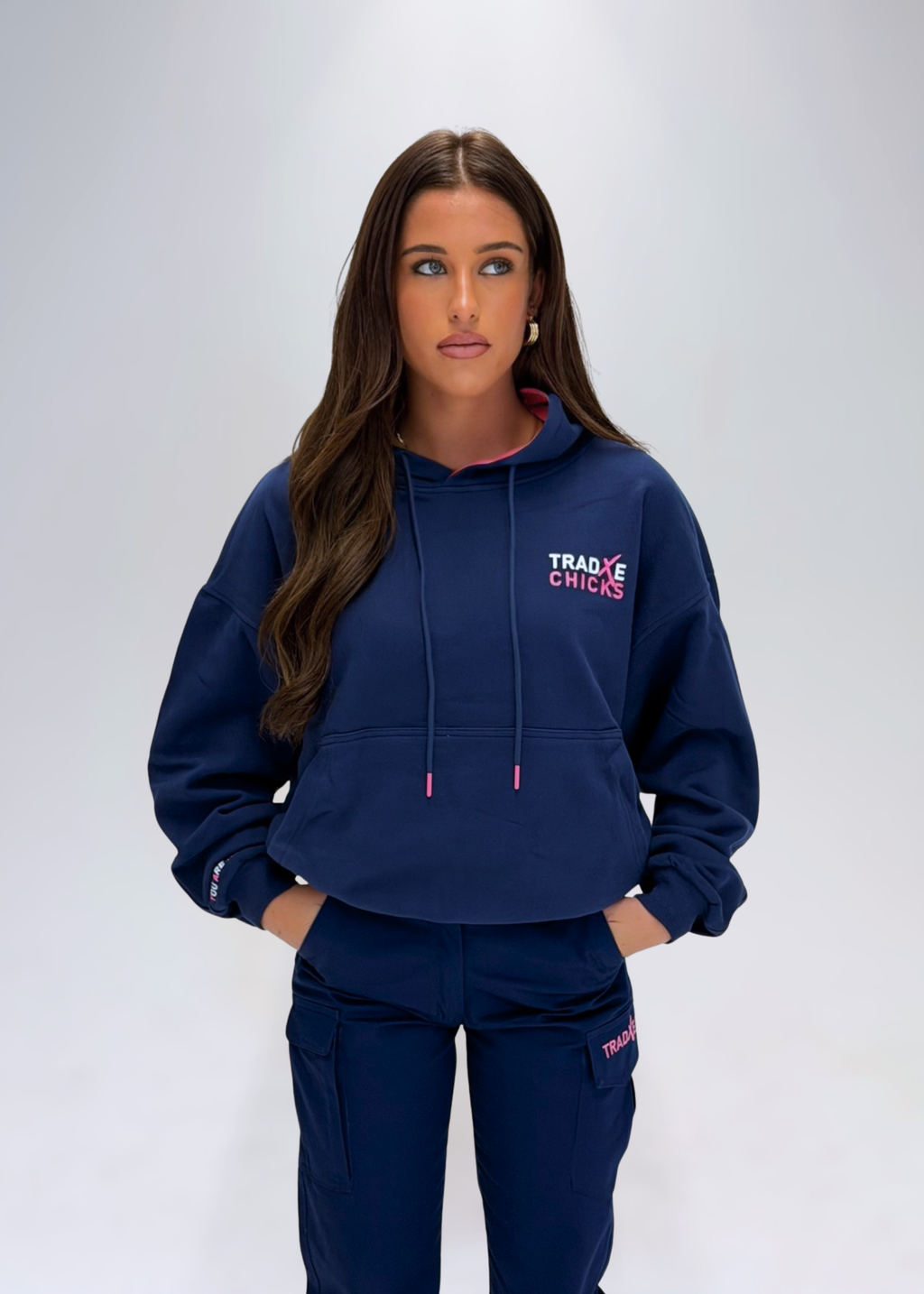 Woman wearing a navy hoodie with 'Tradxe Chicks' logo on a white background